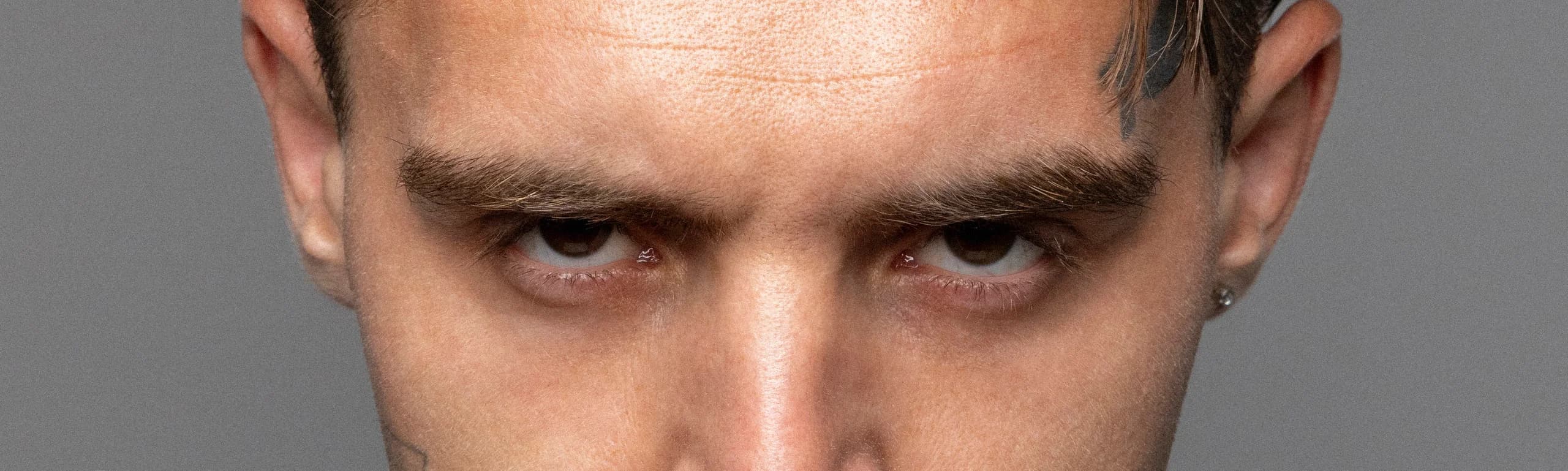 Detail Rohonyho očí — studiový portrét se zrnem